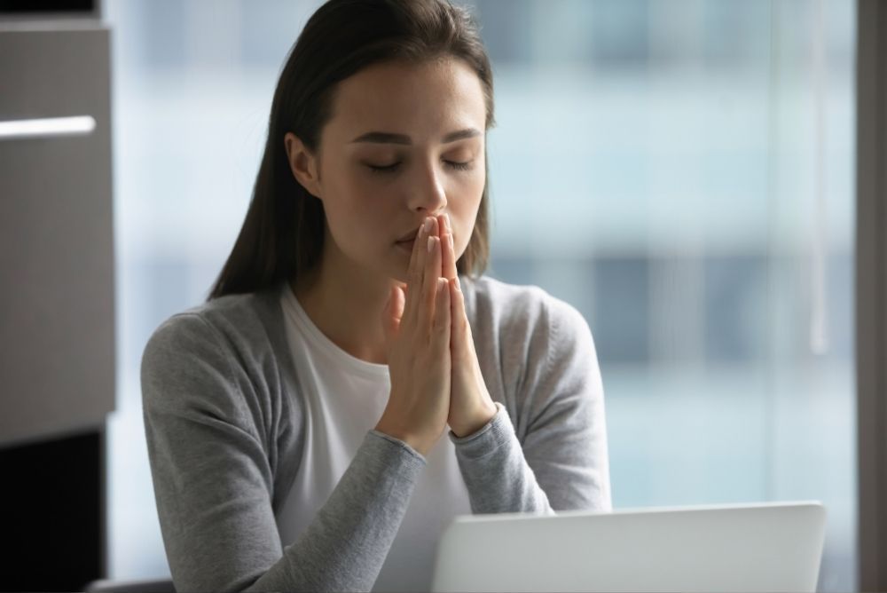 woman praying at computer